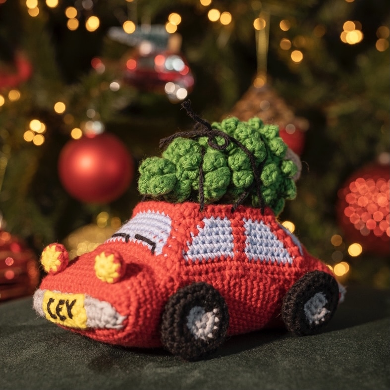 gehaakte rode auto met kerstboom op het dak